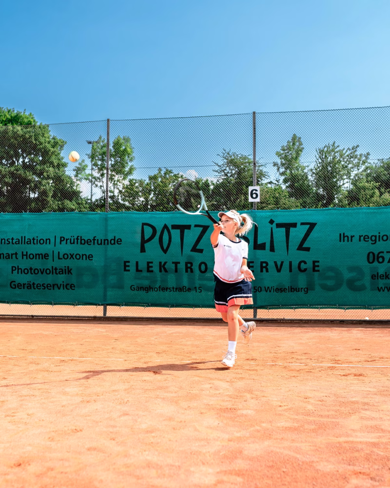 Kinder beim Tennisspielen.